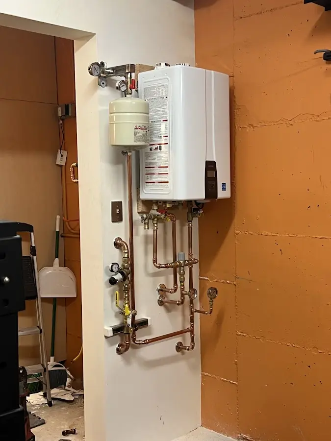 Plumbing technician inspecting water heater connections in Schertz